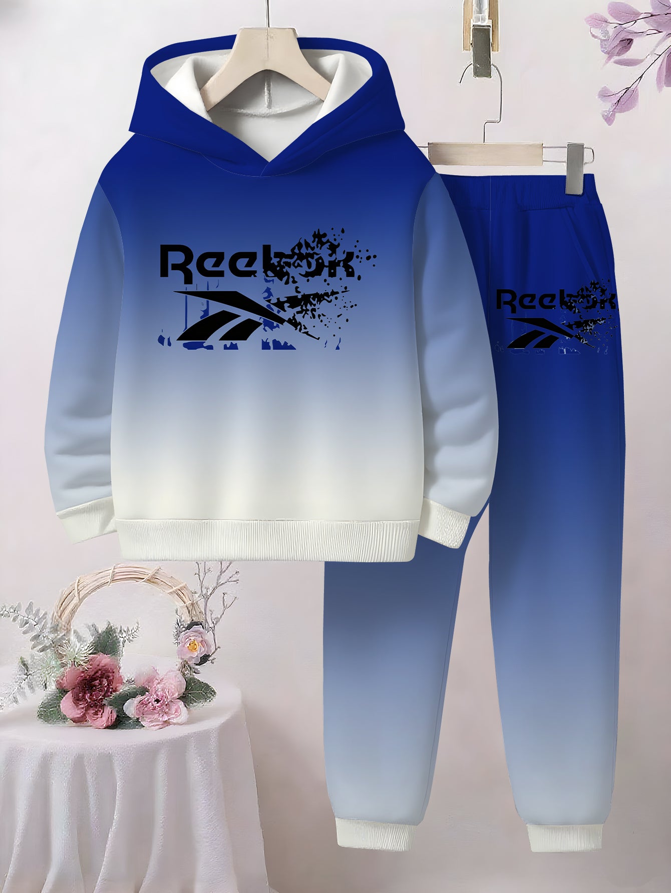 Boys' Gradient Hooded Tracksuit Set. This two- piece casual sportswear features a blue- white gradient. It's a themed hooded tracksuit set that showcases a sporty style, making it a trendy and comfortable choice for boys in s